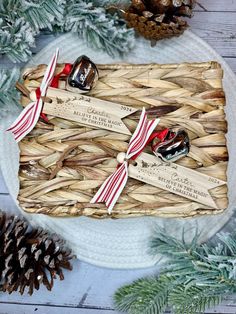 a basket filled with christmas decorations on top of a white plate next to pine cones