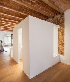 an empty room with wooden floors and exposed brick walls in the center of the room