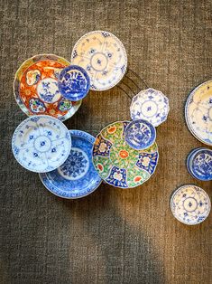 an overhead view of several colorful plates on a brown table cloth, with one plate in the middle