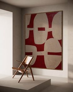 a chair sitting in front of a painting on the wall