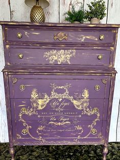 an old dresser painted purple with gold trim