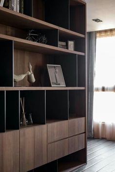 a living room filled with lots of wooden shelves