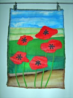 an art project with red flowers on a green field