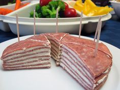 a sandwich cut in half on a plate with toothpicks sticking out of it