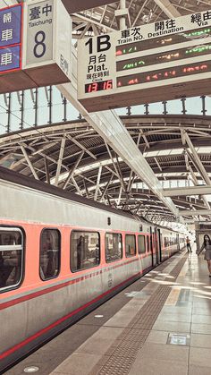 a train station with people walking on the platform