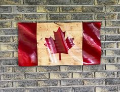 a wooden canadian flag hanging on a brick wall