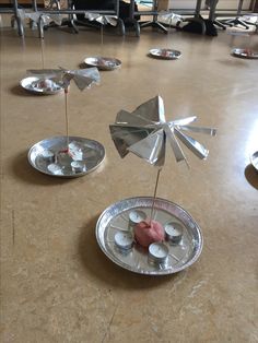 several silver plates with small umbrellas on them sitting on a table in a room