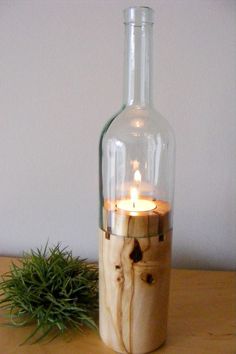 a bottle with a candle inside sitting on a table