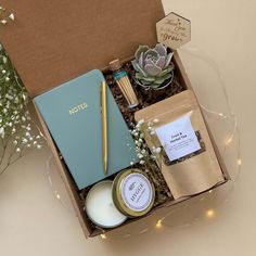 an open box with candles, flowers and other items in it sitting on a table