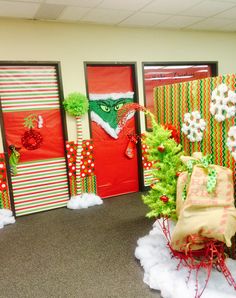 christmas decorations are displayed in front of red doors with green and white trimmings