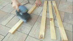 a person using a sander on wood planks to cut them into smaller pieces