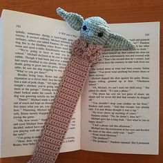 an open book with a crocheted giraffe head on it