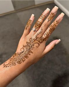 a woman's hand with henna tattoos on it