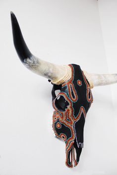 a bull's skull with long horns decorated with beads