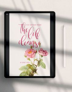 there is a book cover with pink flowers on the front and back covers, along with a pen