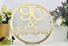 there is a cake topper that says 90 and fabulous on it next to some flowers