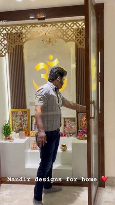 a man standing in front of a mirror with his hand on the glass door handle