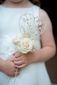 a close up of a person wearing a dress and holding a flower in their hand