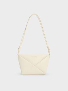 This product is made with at least 20% sustainable materials by weight. CHARLES & KEITH uses recycled, degradable, organic, and water-based materials in our eco-conscious collection. Offering versatility in a visually interesting silhouette, this Midori crossbody is the perfect accessory to enliven any outfit. The sleek cream finish lets the clean, elegant lines of the geometric folds stand out, giving the minimalist design a pleasing tactility. The knotted details on the strap are understated yet distinctive. Fitted with a zip closure that will keep your belongings secure, this stylish and practical bag can be carried on the shoulder or across the body. Clear Backpacks, White Shoulder Bags, Chic Crossbody Bag, Practical Bag, Size Chart For Kids, Charles Keith, Black Crossbody, Black Cross Body Bag, Online Bags