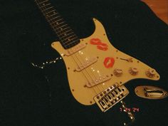 an electric guitar with lipstick painted on it's body and pick - up buttons