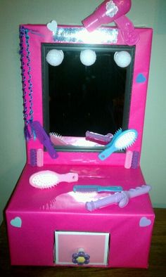 a pink vanity with hairbrushes, combs and mirror on top of it