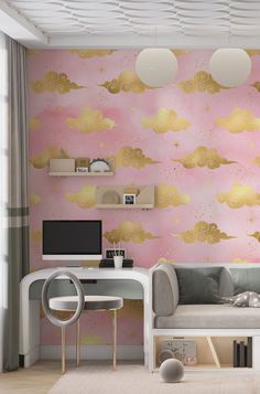 a living room with pink walls and gold clouds on the wall, along with a gray couch