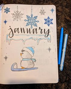 a notebook with the word january written on it next to two markers and a pen