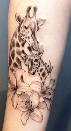 a giraffe and its baby are depicted on this tattoo artist's leg