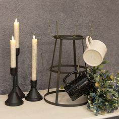 three candles are sitting on a shelf next to some other items