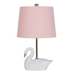 a white swan lamp with a pink shade on it's head and body, sitting next to a light