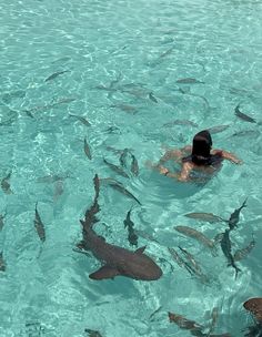 a man swimming in the ocean surrounded by fish