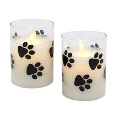 Accent your home with this adorable pair of battery operated Paw Prints flickering flame candles. The natural flickering flame creates the illusion of a real candle. The clear glass includes genuine poured wax and an enclosed flickering LED light with a six hour timer. The flickering flame looks so real and casts natural light, you'll think it's a real flame. Each candle requires 3 AAA batteries (not included). Product Details: - Set of 2 Battery Operated Candles - Wax and Glass Construction - T Glass Candles, Real Flame, Wall Art Lighting, Battery Operated Candles, Solar String Lights, So Real, Candle Flames, Fairy String Lights, Glass Printing