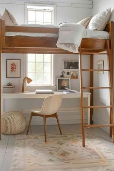 a loft bed with a desk underneath it and ladders to the top, in front of a window