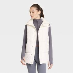 Women's Long Puffer Vest - All In Motion™ Cream XS Spring Functional Puffer Jacket For Outdoor Activities, Functional Spring Puffer Jacket For Outdoor Activities, Sleeveless Down Puffer Jacket For Cold Weather, Functional Sleeveless Outerwear For Fall, Functional Vest For Outdoor Activities In Fall, Puffer Vest For Outdoor Activities In Fall, Casual Sleeveless Puffer Jacket For Cold Weather, Sleeveless Down Puffer Jacket, Fall Puffer Vest For Outdoor Activities