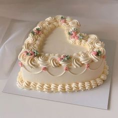 a heart shaped cake sitting on top of a white table