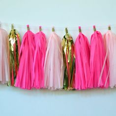 pink and gold tissue tassels hanging from clothes pins