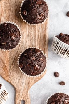 four chocolate muffins on a wooden board