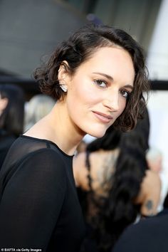 a woman with dark hair wearing a black dress