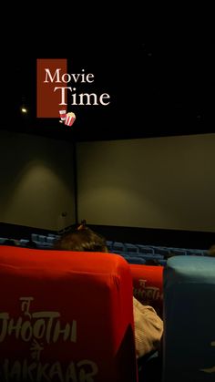 an empty movie theater with people sitting in the seats looking at something on the screen