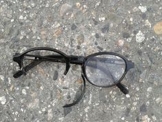 a pair of glasses sitting on the ground with a quote about vision in front of it