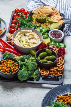 an assortment of vegetables and dips on a tray