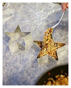 two star shaped cookie tins being filled with bird seed