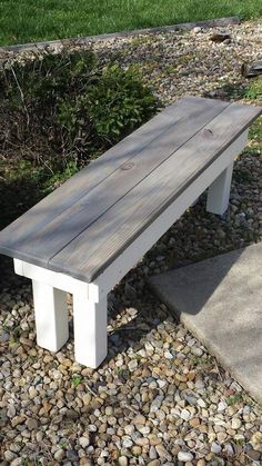 a white bench sitting on top of a pile of rocks