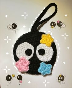 a crocheted key chain with an emo smiley face and bow on it