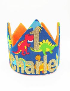 Description: This handmade crown is made from 100% cotton fabric and two layers of eco-fi felt to ensure quality to last for years of play! Our crowns are perfect for Birthdays, Special Occasions, Pretend Play, and Dress up! They've been toddler tested and approved for comfort and durability =) Best of all, our crowns are reversible, you get two crowns for one!! Materials: Cotton Fabric, Eco-fi Felt, & Thread Sizing: Each crown is adjustable with a convenient velcro enclosure on the back. They c Dinosaur Crown, Dinosaur Party Hats, Handmade Crown, First Birthday Crown, First Birthday Hats, Fabric Crown, Felt Crown, Crown Party, Custom Crown