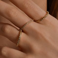 a woman's hand with a gold ring on her finger and diamond band around it