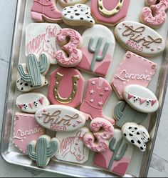 decorated cookies in the shape of horses, cactuses and other things on a tray