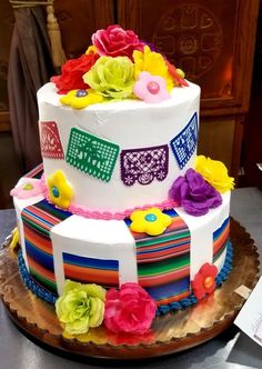 a multi - layered cake decorated with flowers and ribbons