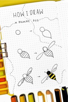 an open notebook with bees drawn on it next to markers and pencils in different colors