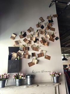 several vases with flowers are on the wall above an old fireplace in a restaurant